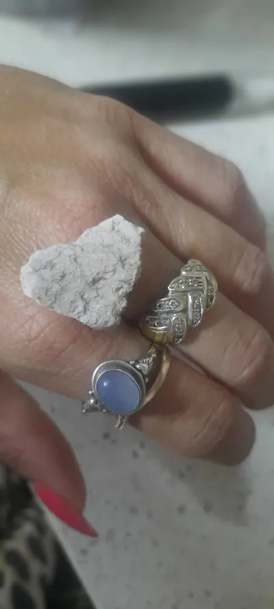 Una pietra bianca a forma di cuore tra gli anelli